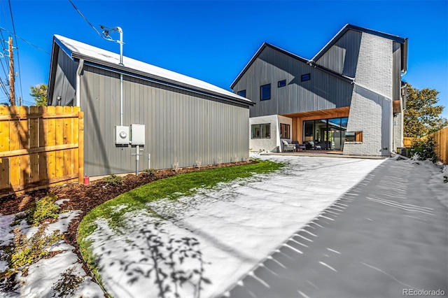 exterior space with an outbuilding, brick siding, and fence