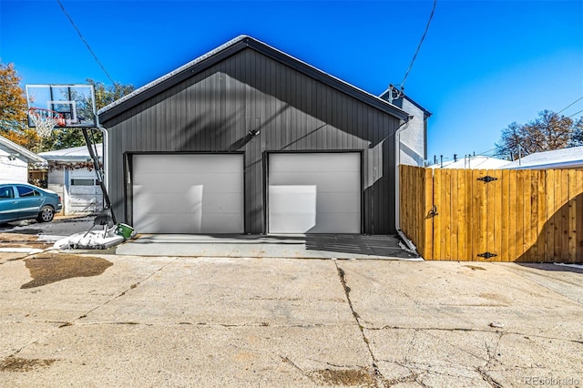 detached garage featuring fence