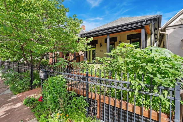 3313 Curtis St, Denver, CO 80205 - view of front facade featuring a shingled roof and covered porch