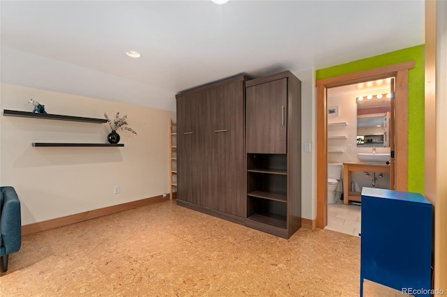 3313 Curtis St, Denver, CO 80205 - unfurnished bedroom featuring a sink, baseboards, and ensuite bath