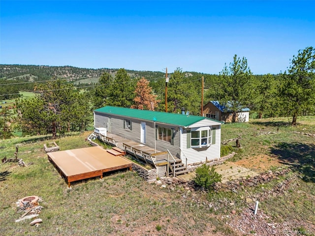 332 Valley Cir, Guffey, CO 80820 - rear view of property featuring a wooden deck, a view of trees, and a metal roof
