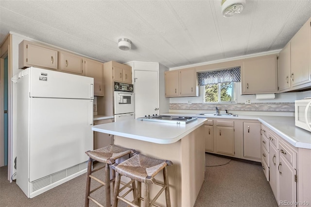 332 Valley Cir, Guffey, CO 80820 - kitchen featuring white appliances, cream cabinets, a center island, and light countertops