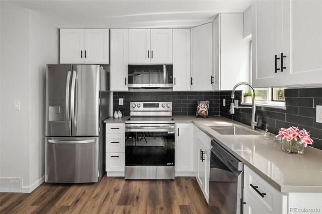 13438 E 13th Pl, Aurora, CO 80011 - kitchen featuring backsplash, dark wood-style flooring, visible vents, a sink, and stainless steel appliances