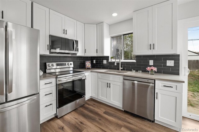 13438 E 13th Pl, Aurora, CO 80011 - kitchen featuring white cabinets, appliances with stainless steel finishes, a sink, light countertops, and backsplash