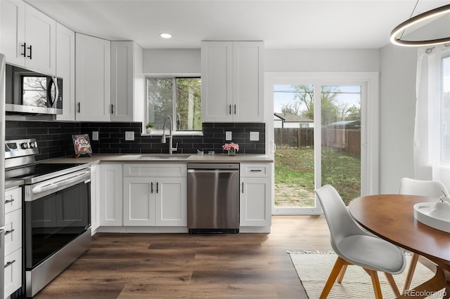 13438 E 13th Pl, Aurora, CO 80011 - kitchen with a sink, white cabinetry, appliances with stainless steel finishes, and backsplash