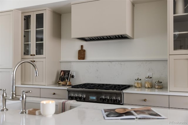 4131 Quivas St, Denver, CO 80211 - kitchen with range, light countertops, custom exhaust hood, backsplash, and glass insert cabinets