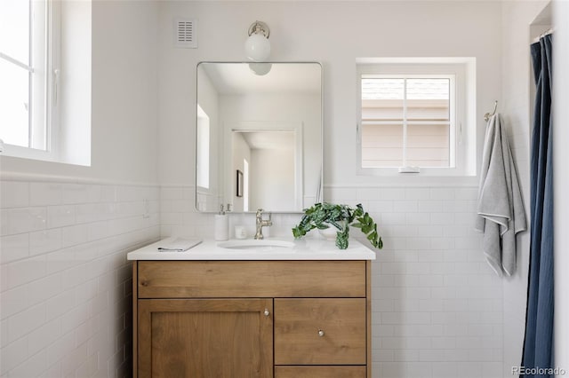 4131 Quivas St, Denver, CO 80211 - bathroom with vanity, tile walls, and wainscoting