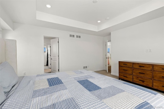 carpeted bedroom featuring a tray ceiling