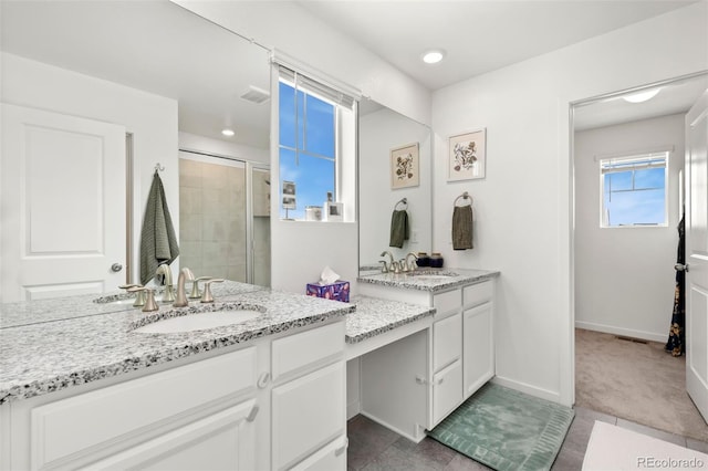 bathroom with a shower with door and vanity