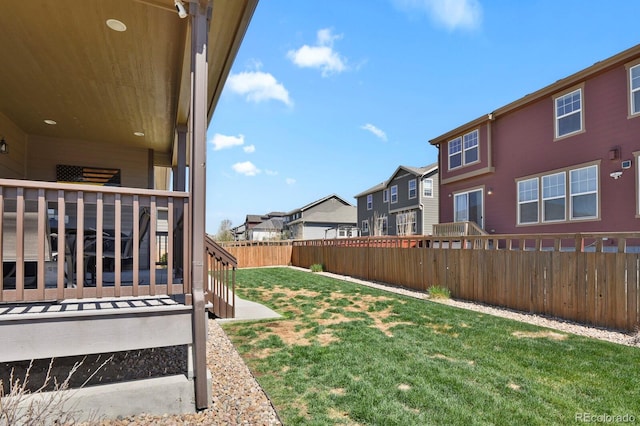 view of yard with a residential view, a fenced backyard, and a deck