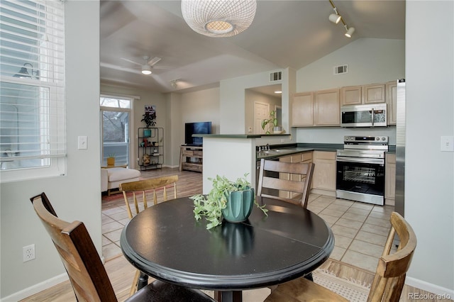 dining space with visible vents, baseboards, lofted ceiling, and track lighting