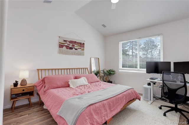 bedroom with visible vents, wood finished floors, baseboards, ceiling fan, and vaulted ceiling