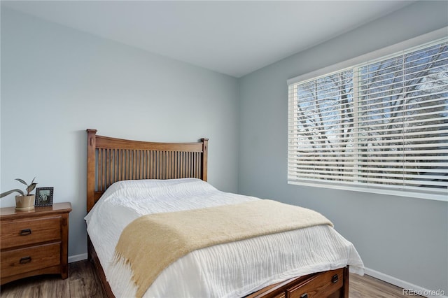 bedroom featuring baseboards and wood finished floors