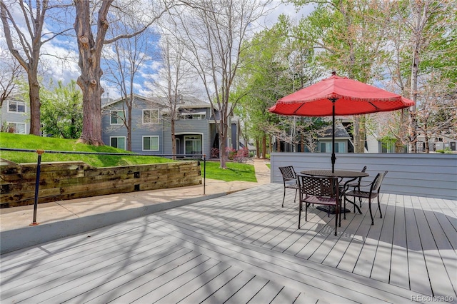 wooden terrace with a yard and outdoor dining space