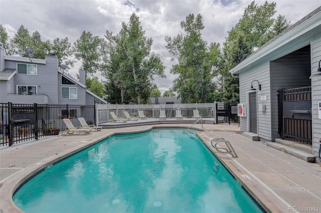 pool featuring fence and a patio