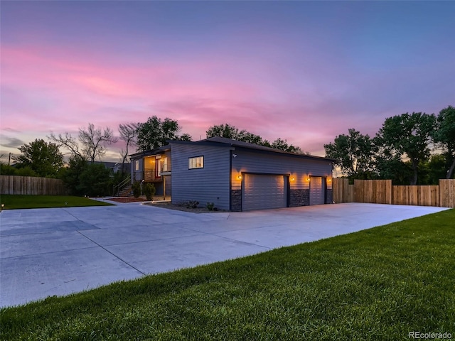 view of front facade with driveway, a front lawn, and fence