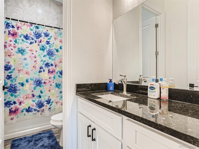 bathroom featuring a shower with curtain, toilet, vanity, and a textured wall