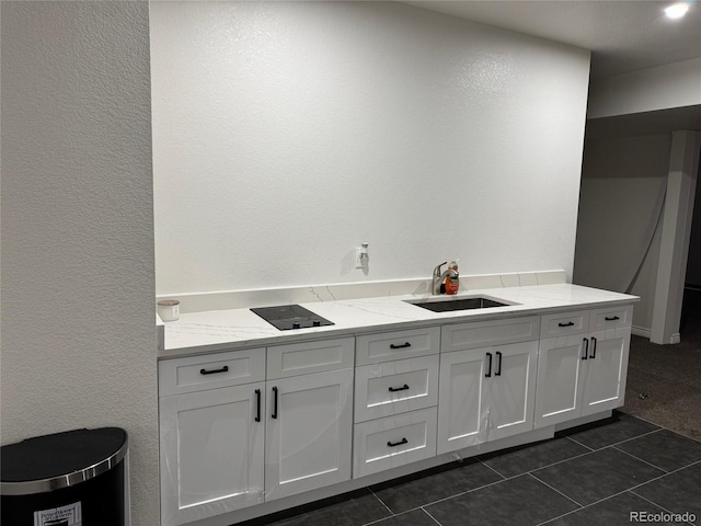 interior space featuring tile patterned floors, a textured wall, and a sink