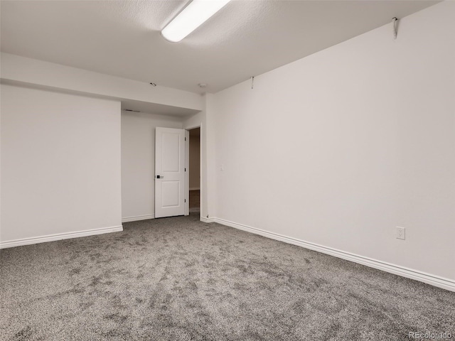 carpeted empty room featuring baseboards