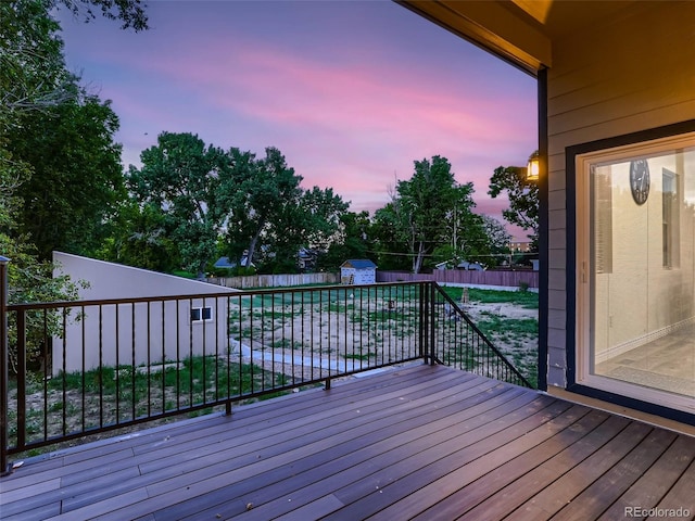 wooden terrace with a fenced backyard, a shed, and an outdoor structure