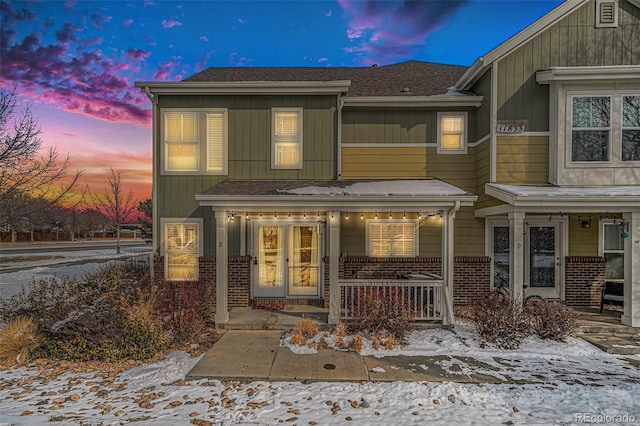 exterior space featuring covered porch and brick siding