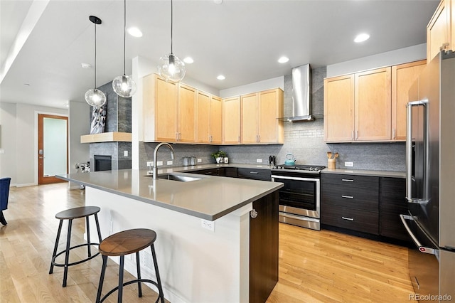 1376 Snowberry Ln, Louisville, CO 80027 - kitchen featuring stainless steel stove, wall chimney exhaust hood, high end refrigerator, light brown cabinets, and a peninsula