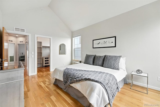 1376 Snowberry Ln, Louisville, CO 80027 - bedroom featuring high vaulted ceiling, a walk in closet, light wood-style floors, and a closet