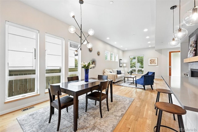 1376 Snowberry Ln, Louisville, CO 80027 - dining space with light wood finished floors, a glass covered fireplace, and recessed lighting