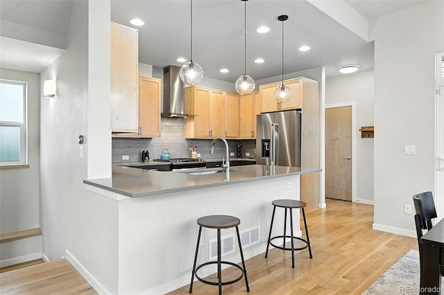 1376 Snowberry Ln, Louisville, CO 80027 - kitchen featuring wall chimney range hood, high quality fridge, light brown cabinetry, a peninsula, and tasteful backsplash
