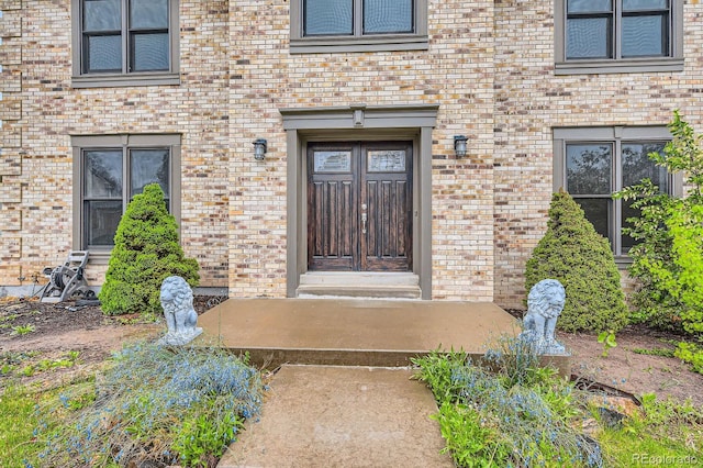 view of exterior entry featuring brick siding