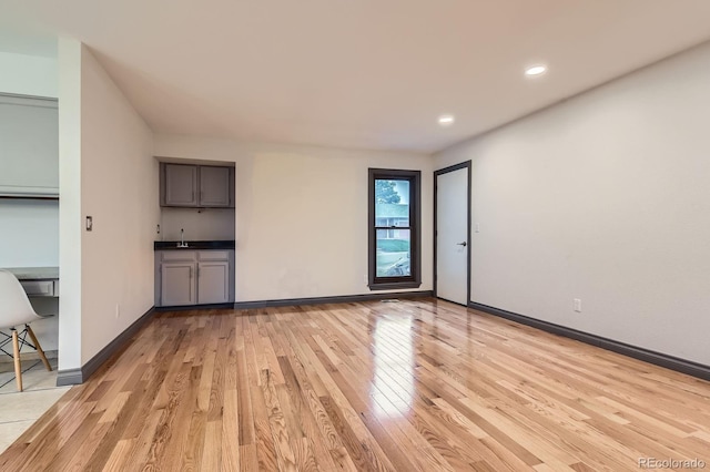 unfurnished living room featuring light wood-style flooring, recessed lighting, and baseboards