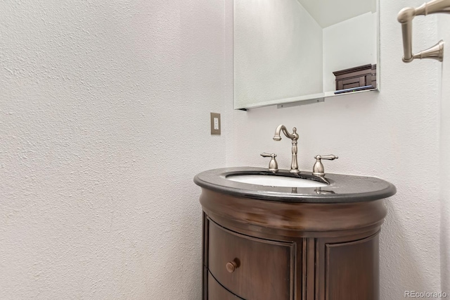 bathroom featuring a textured wall and vanity