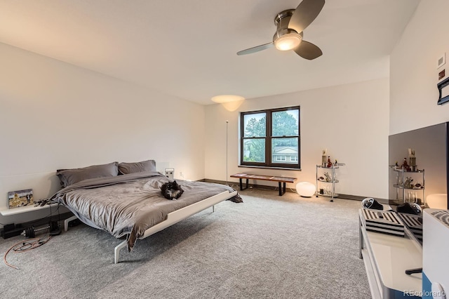 carpeted bedroom with ceiling fan and baseboards