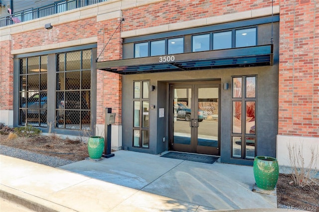 doorway to property featuring french doors and brick siding