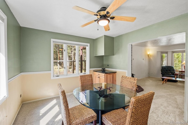 dining space with light colored carpet and ceiling fan