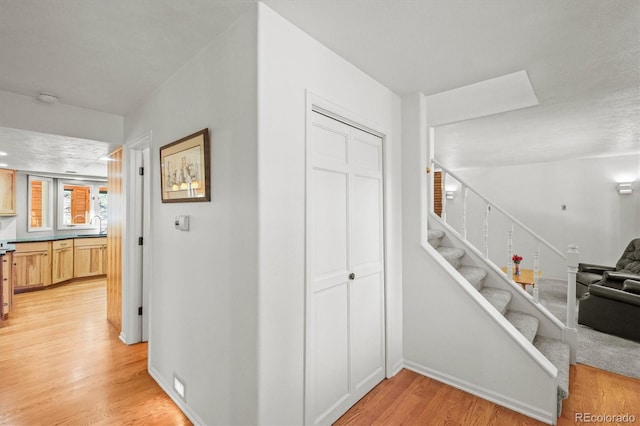 hall with light hardwood / wood-style floors and sink