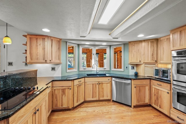 kitchen featuring sink, kitchen peninsula, stainless steel appliances, and light wood-type flooring