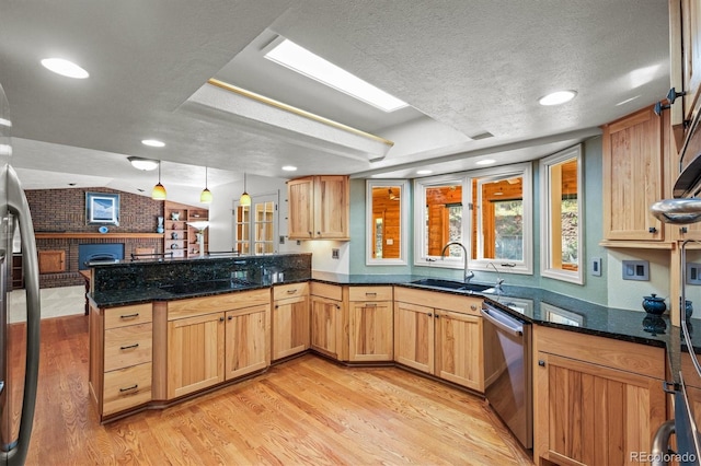 kitchen with light hardwood / wood-style floors, kitchen peninsula, dishwasher, and a textured ceiling