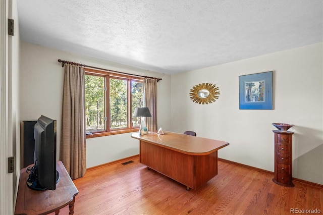 office space with light hardwood / wood-style flooring and a textured ceiling