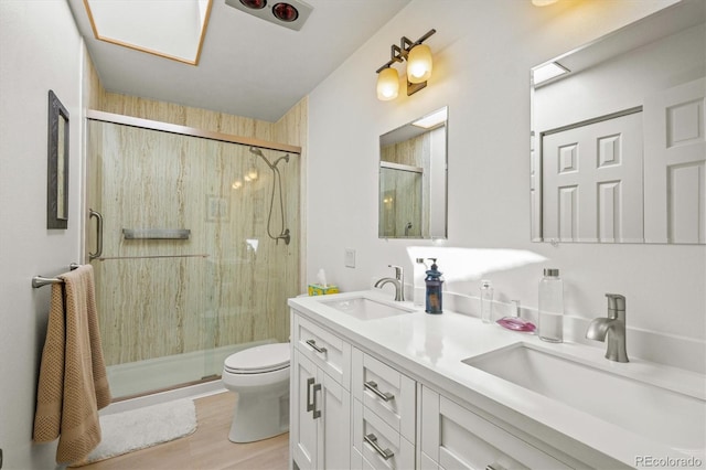 bathroom with vanity, toilet, a shower with door, and hardwood / wood-style floors