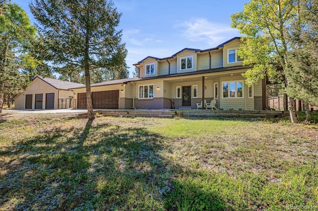 view of front of home with a porch, a front lawn, and a garage