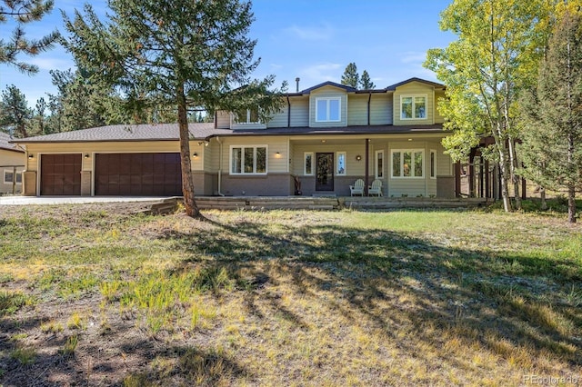 view of front of house with a porch, a front lawn, and a garage