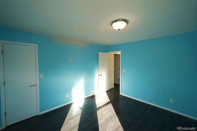 spare room with dark wood-type flooring