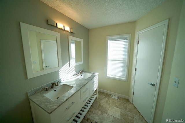 bathroom with a textured ceiling and vanity