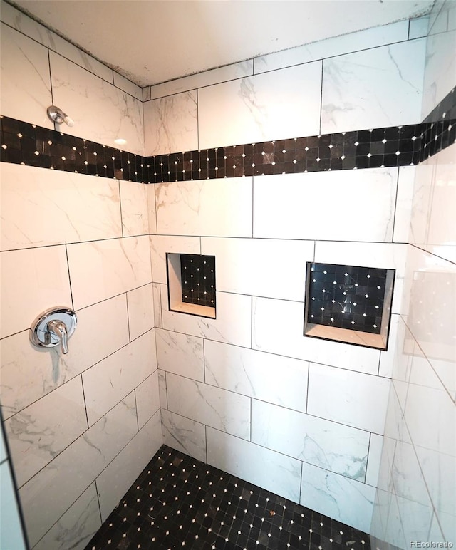 bathroom with a tile shower and a mail area