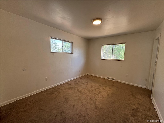 spare room with dark carpet