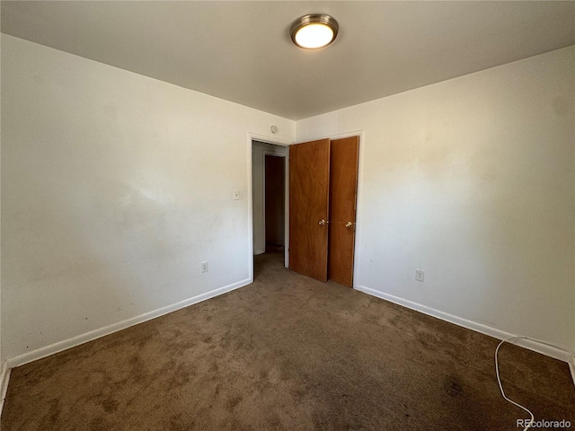 spare room with dark colored carpet