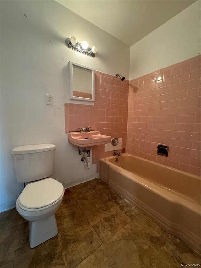 full bathroom featuring tiled shower / bath combo, sink, decorative backsplash, and toilet