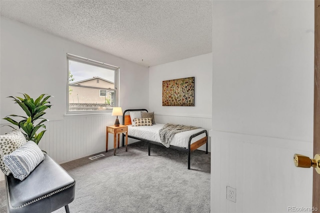 8479 Rabbitbrush Way, Parker, CO 80134 - bedroom featuring a wainscoted wall, a textured ceiling, and carpet