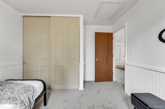 8479 Rabbitbrush Way, Parker, CO 80134 - carpeted bedroom featuring a closet, a wainscoted wall, and attic access